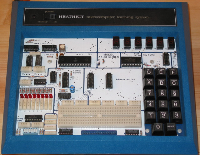 Heathkit ET-3400A Microprocessor trainer is a single board computer with a hex keypad, 6 seven-segment LED displays, on the board are several solder-less connection points and an empty solderless protoblock.  Silkscreen on the board says: MODEL 3400 SERIES