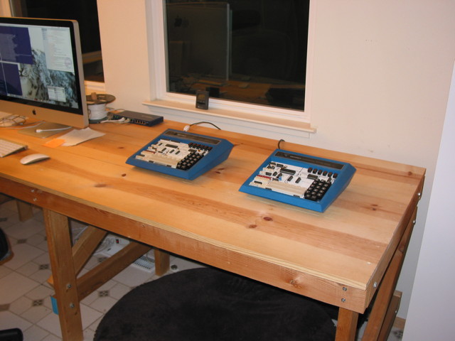 A wooden workbench with an iMac and two Heathkit ET-3400 Microprocessor trainers on it