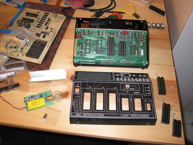 A B&C Microsystems 1409 EPROM Programmer disassembled with ZIF sockets and an ultraviolet lightbulb assembly strewn about.
