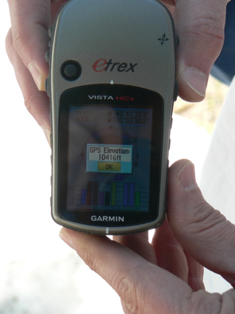 Someone holding a Garmin Etrex Vista HCx handheld GPS.  The display says GPS Elevation: 10416 ft.  There is snow in the background.