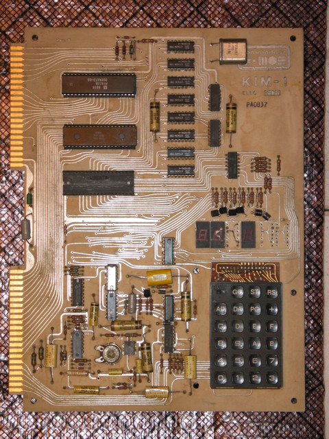 A KIM-1 Single Board Computer.  It says Rev. D and Commodore MOS KIM-1 on it.  3 of the 6 seven-segment LED displays are missing, and one looks beat up pretty bad.  Transistors next to the displays are bent over in different directions.